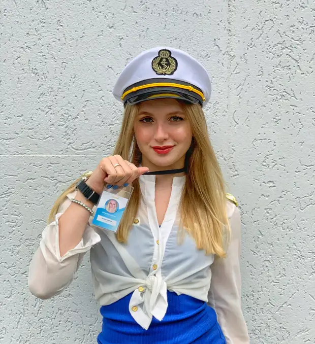 Lívia Dall'Acqua de quepe de comandante, mostrando o crachá da Acqua Digital