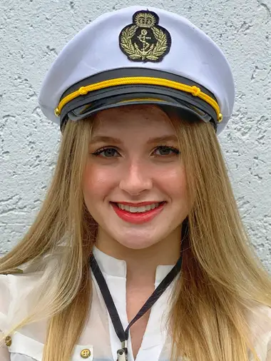 Lívia Dall'Acqua sorrindo, de quepe de comandante